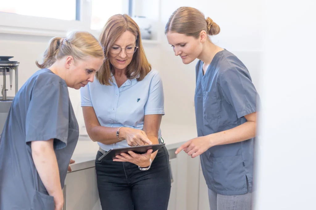 Ärzte am digitalen Gerät für Qualitätsmanagement