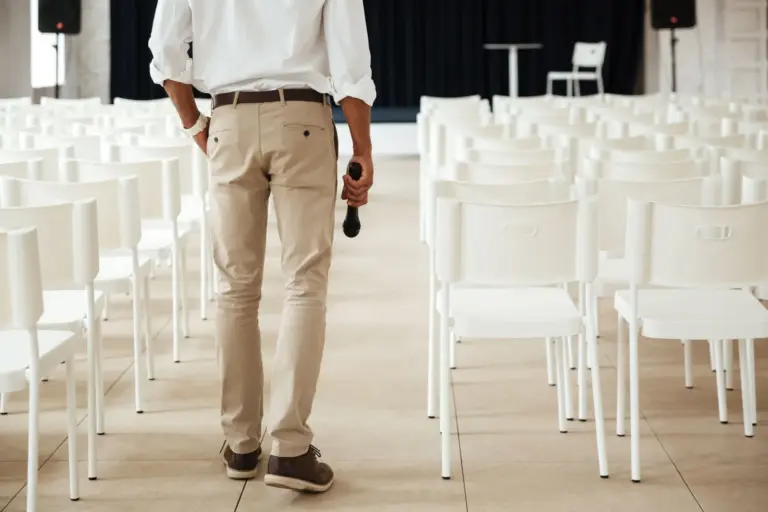 Mann von hinten gezeigt der in einem vorbereiteten Eventsaal steht