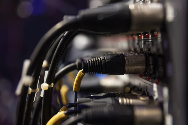 Nahaufnahme der Rückseite eines Hifi-Gerätes in dem einige Klinkenstecker mit Kabeln eingesteckt sind