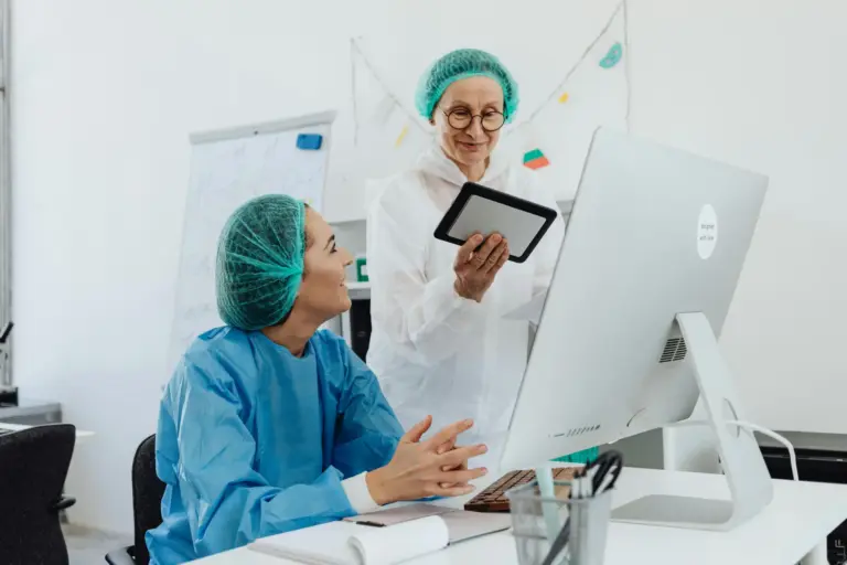 Zwei Mitarbeiter einer Arztpraxis schauen auf ein Tablet