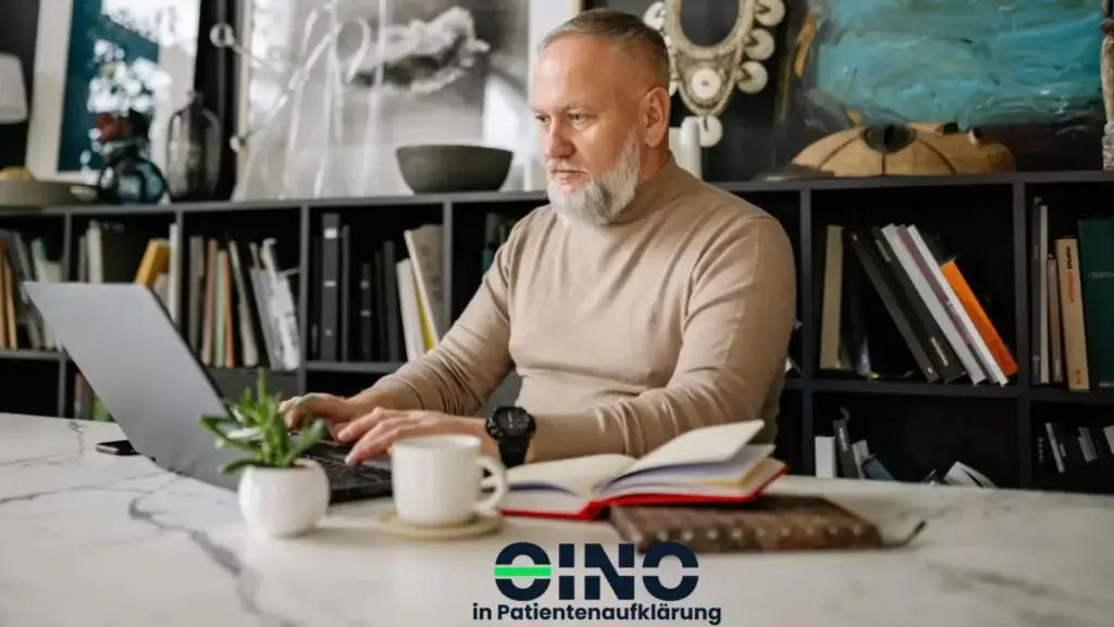 Mann sitzt vor dem Laptop
